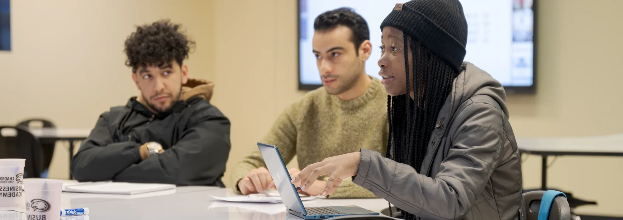 Three students discussing a topic during a graduate business course